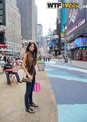 Милая девушка останавливается, чтобы понюхать цветы в джинсовых шортах, прежде чем пойти за пивом